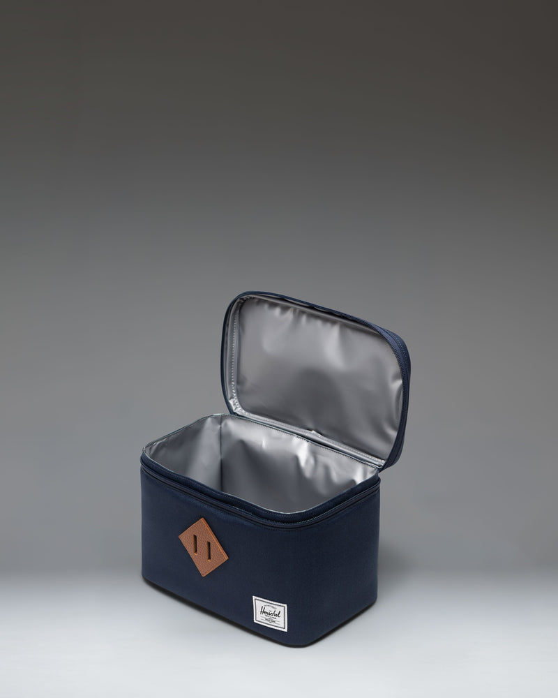 Herschel Heritage Lunch Box in navy blue with insulated interior, top handle, zippered closure, and signature diamond detail.