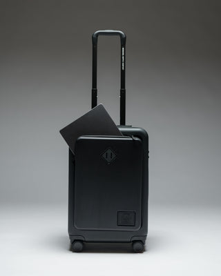 Herschel Heritage Hardshell Pro Large Carry On luggage in Black, shown from the front with a textured hard shell and retractable handle.