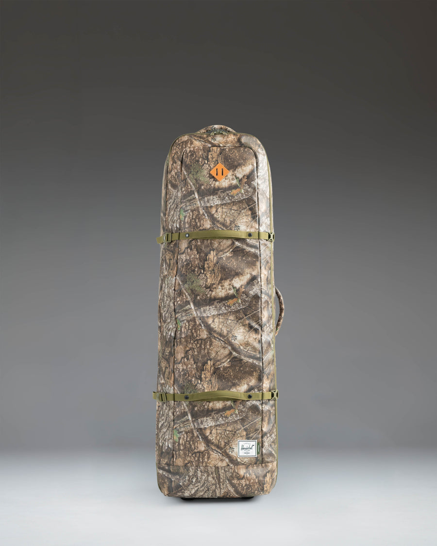 Herschel Heritage Golf Travel Wheelie Bag in Realtree APX Camo pattern, a rolling golf travel case with wheels and a top handle.