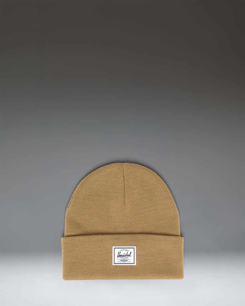 Herschel Supply Co. Elmer Beanie in Antique Bronze brown, showing the classic cuffed knit hat design with a white woven logo label on the front.