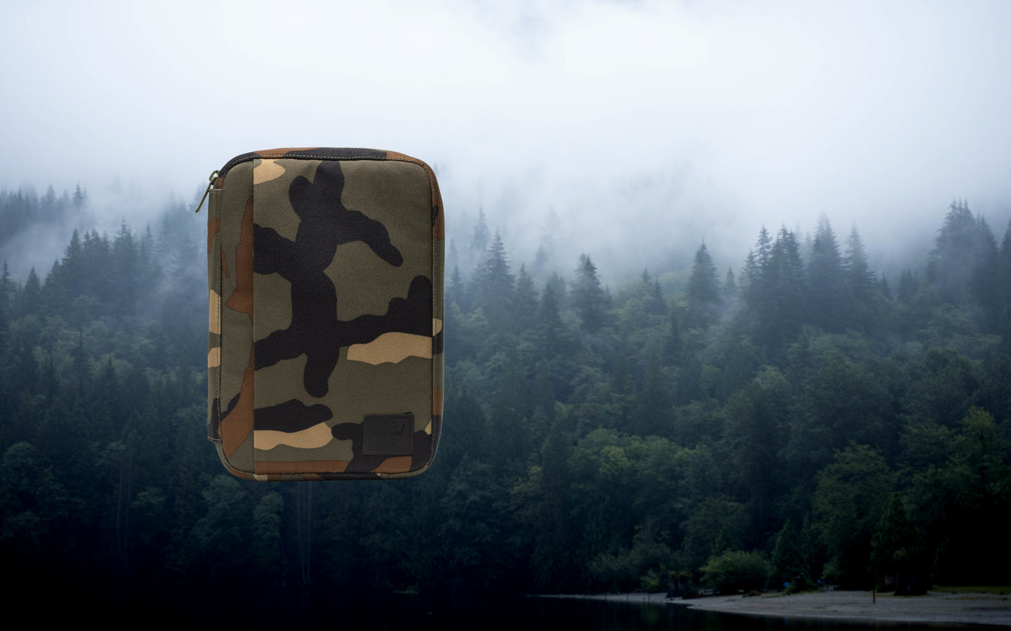 Herschel Supply Co. Burrard Organizer Tech pouch in Woodland Camo pattern, showing a compact zippered design for tech accessories.