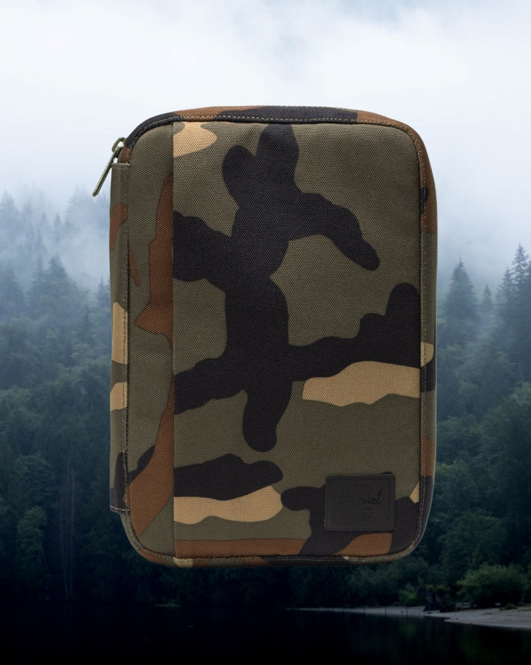 Herschel Supply Co. Burrard Organizer Tech in Woodland Camo patterned fabric, showcasing its compact, rectangular tech accessory storage design.