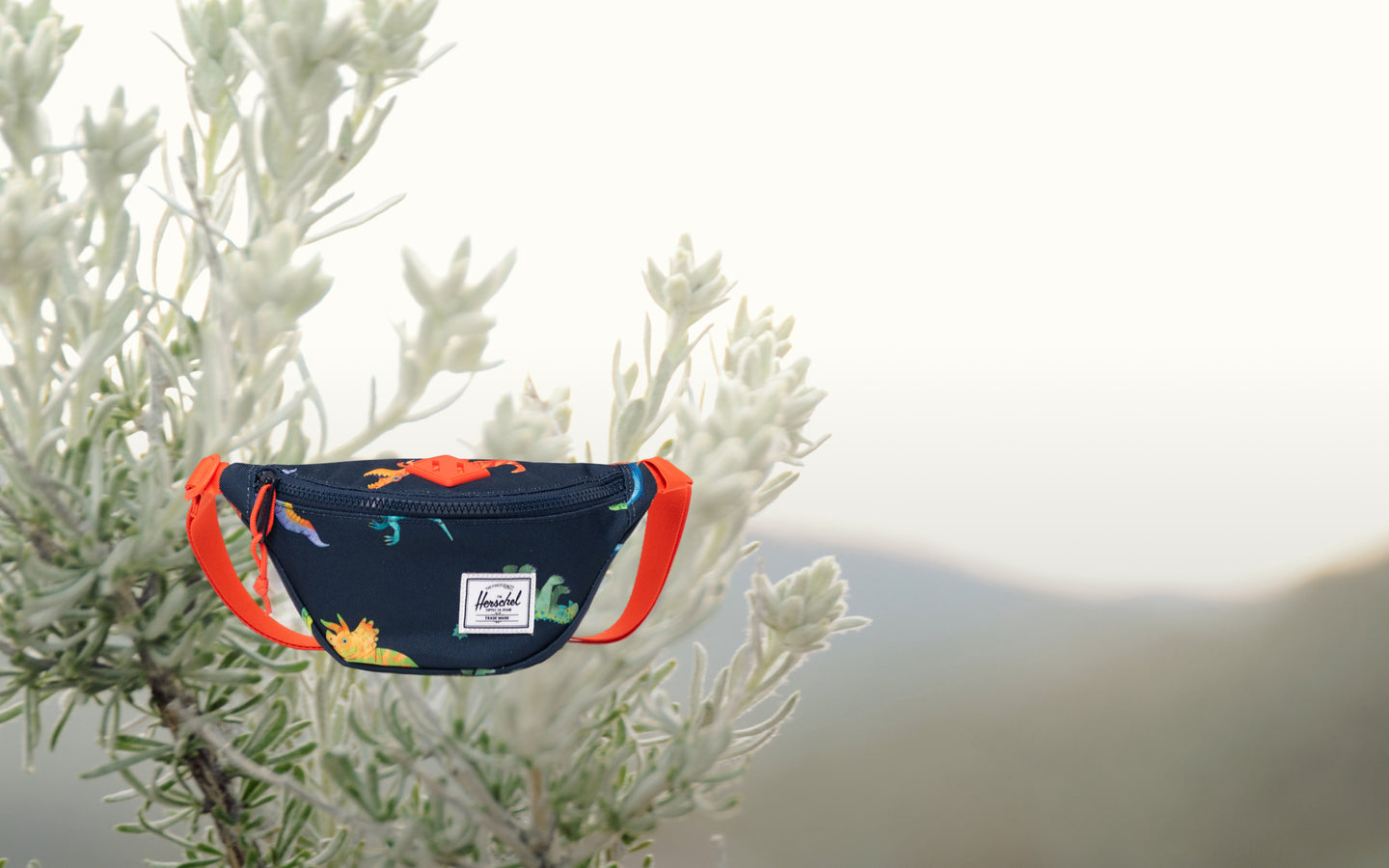 Herschel Heritage Hip Pack Little Herschel in Water Colour Dinosaurs Darkest Navy pattern, shown from the front on a plain background.