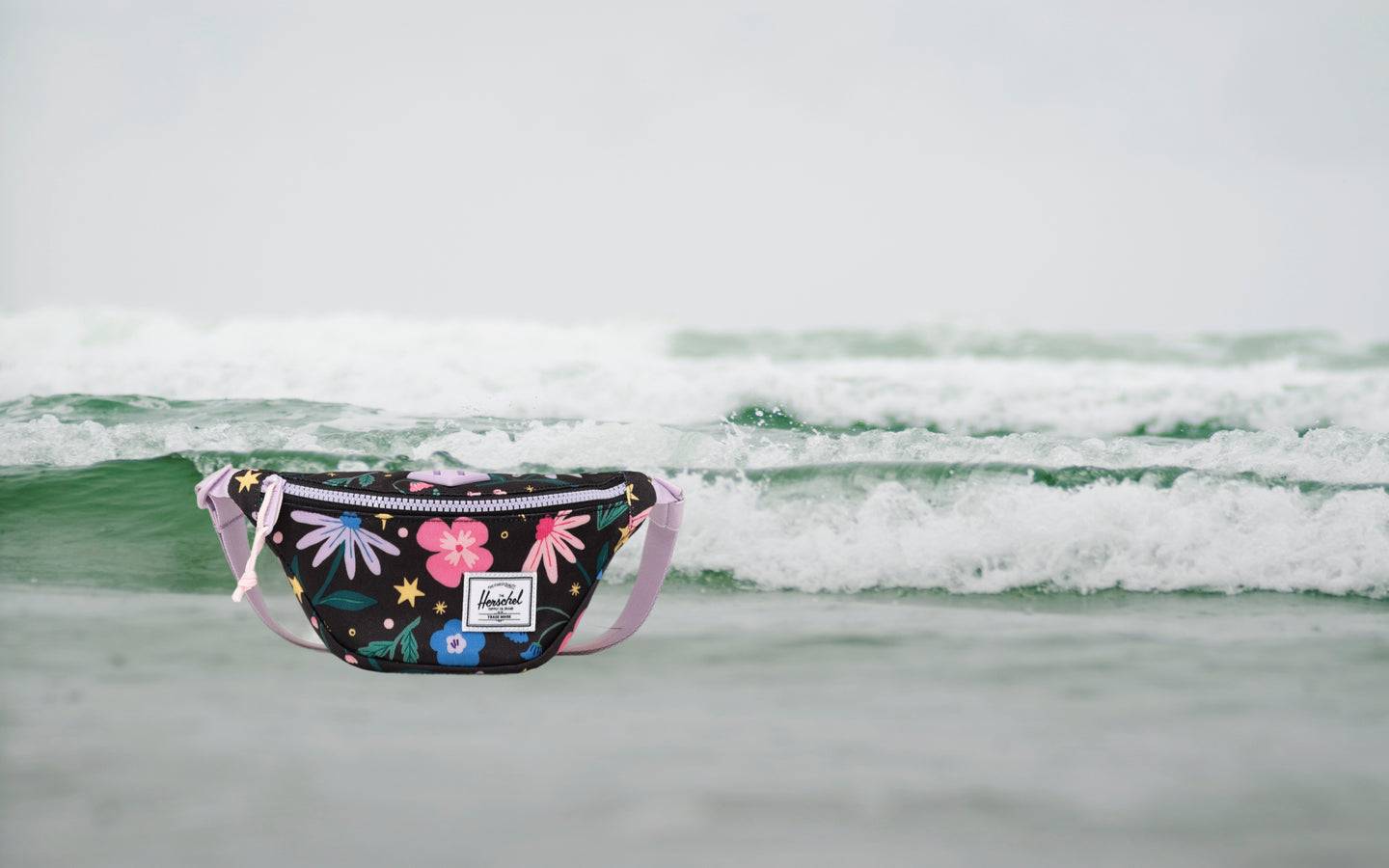 Herschel Heritage Hip Pack Little Herschel in Enchanted Garden floral print, shown from a front lifestyle view.