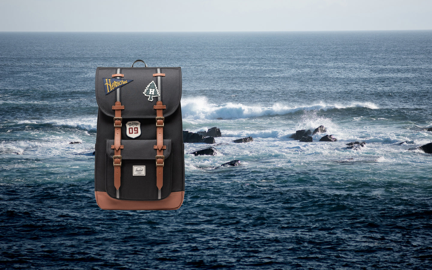Herschel Little America Backpack in Patches Black on a desktop background display.