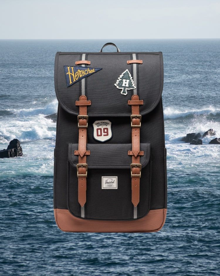 Herschel Little America Backpack in Patches Black, featuring a classic design with rubber straps and a front pocket.