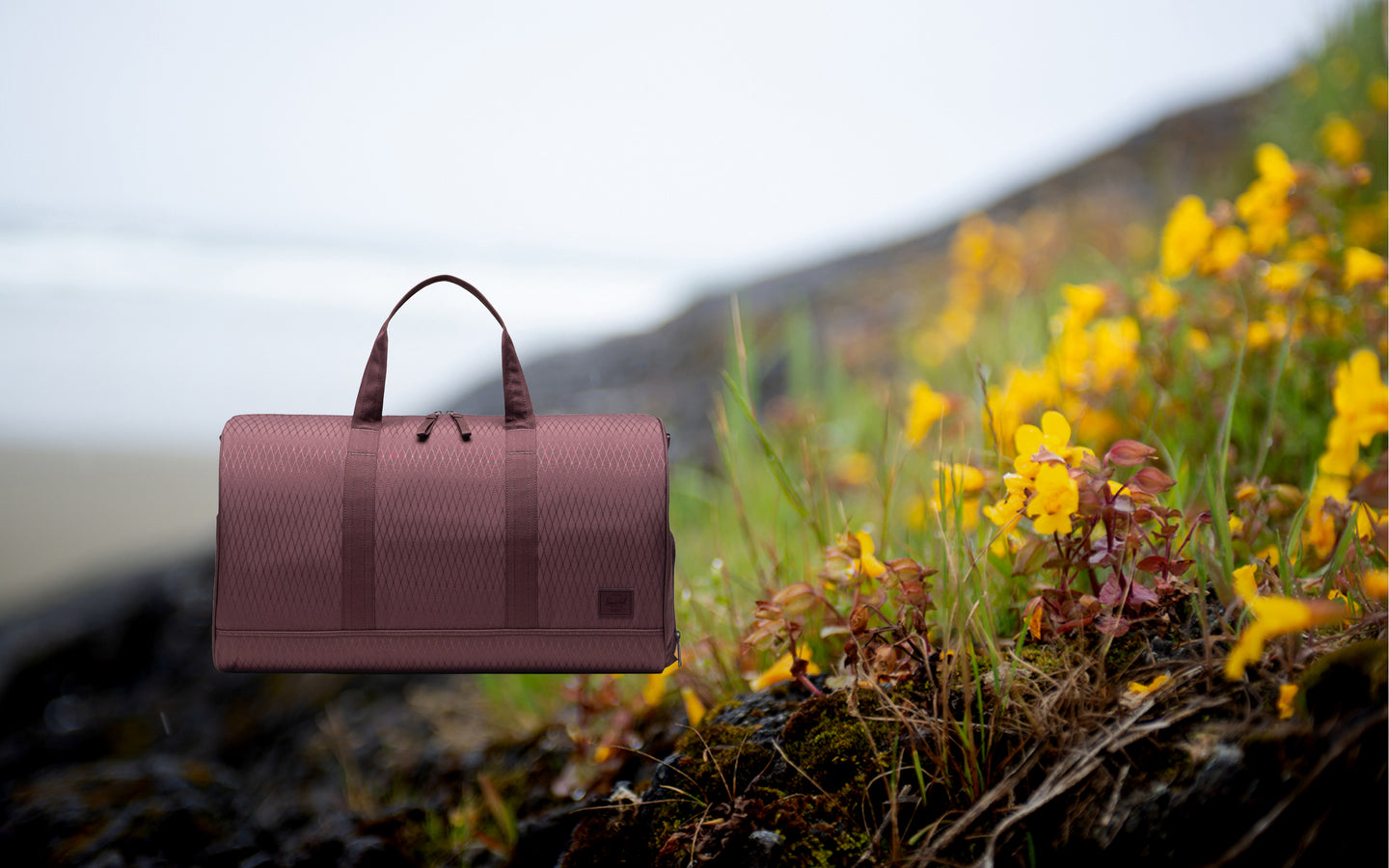 Herschel Novel Duffle bag in Huckleberry Diamond color displayed as a main hero image on a desktop screen.