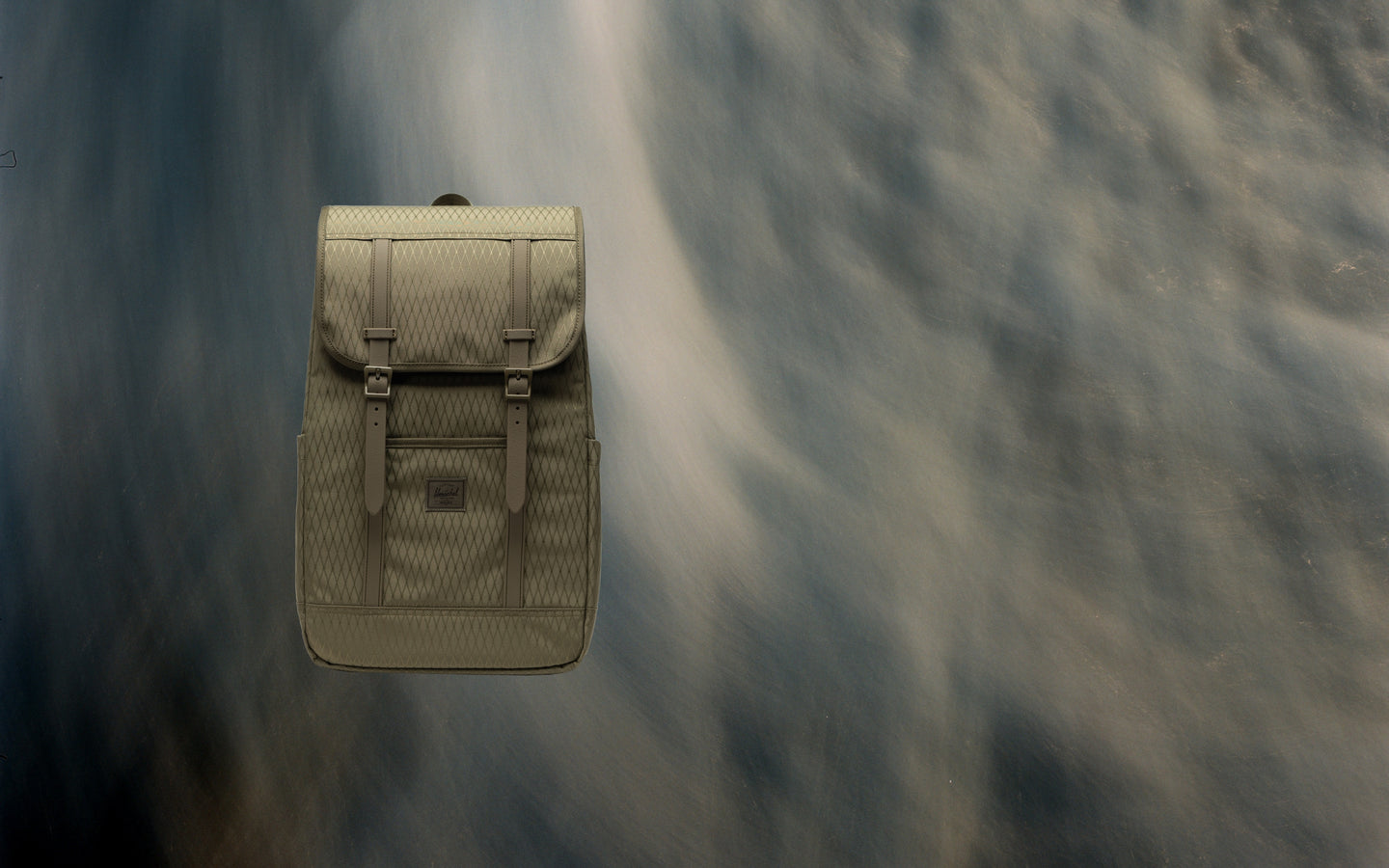 Herschel Retreat Backpack in Ivy Green Diamond shown from the front on a desktop banner.