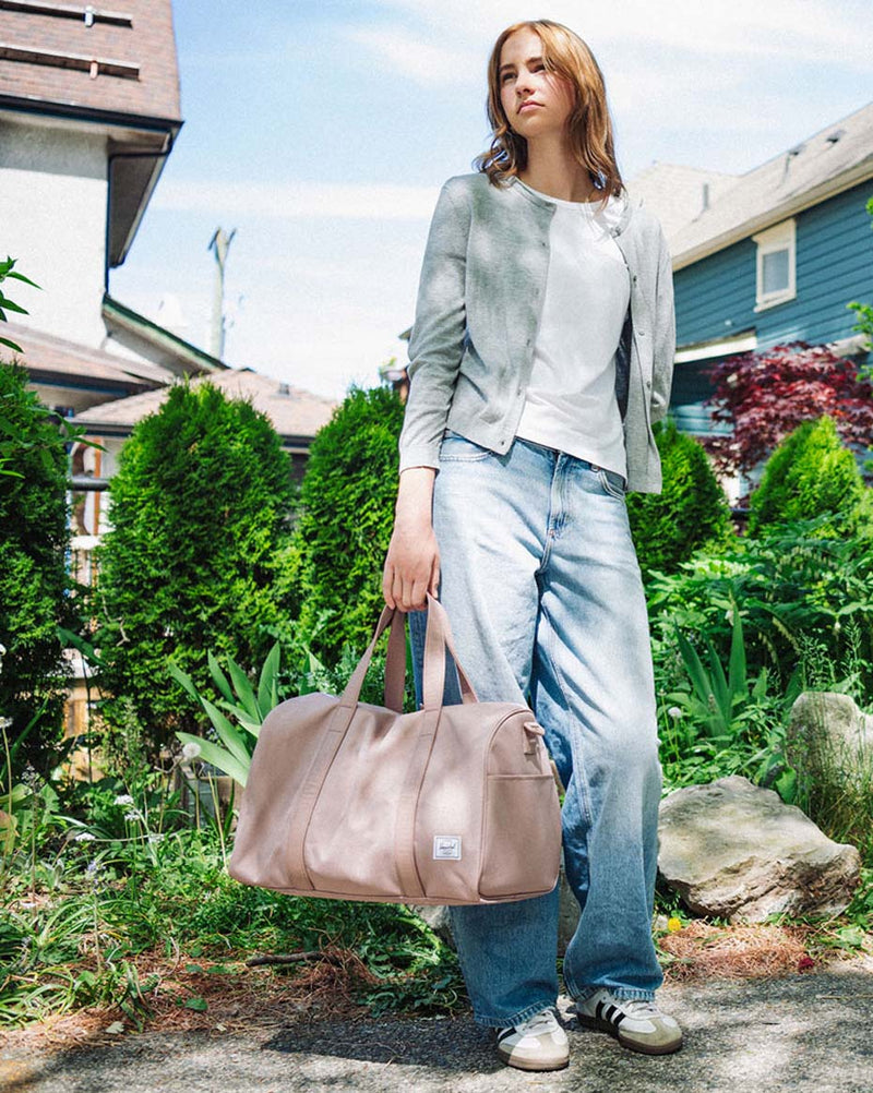 Herschel Novel Carry On Duffle in Ash Rose pink, featuring a main compartment and side shoe pocket.