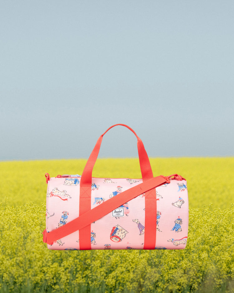 Herschel Classic Duffle Little Herschel in Fashion Dogs print, a kids duffle bag featuring an all-over pattern of various dog breeds.