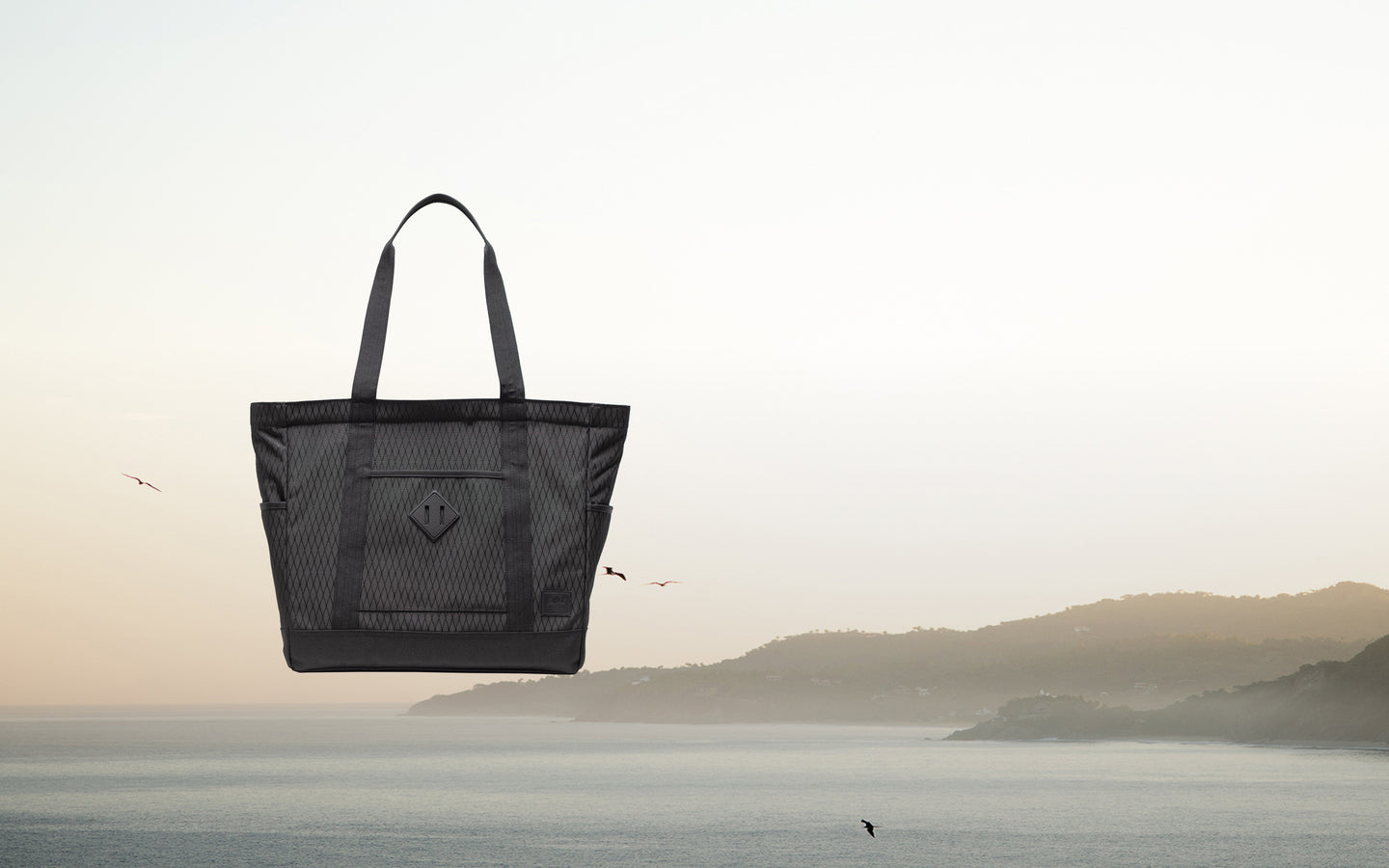 Herschel Heritage Tote in Black Diamond/Black. A classic black tote bag featuring a durable diamond-patterned fabric detail on the bottom.