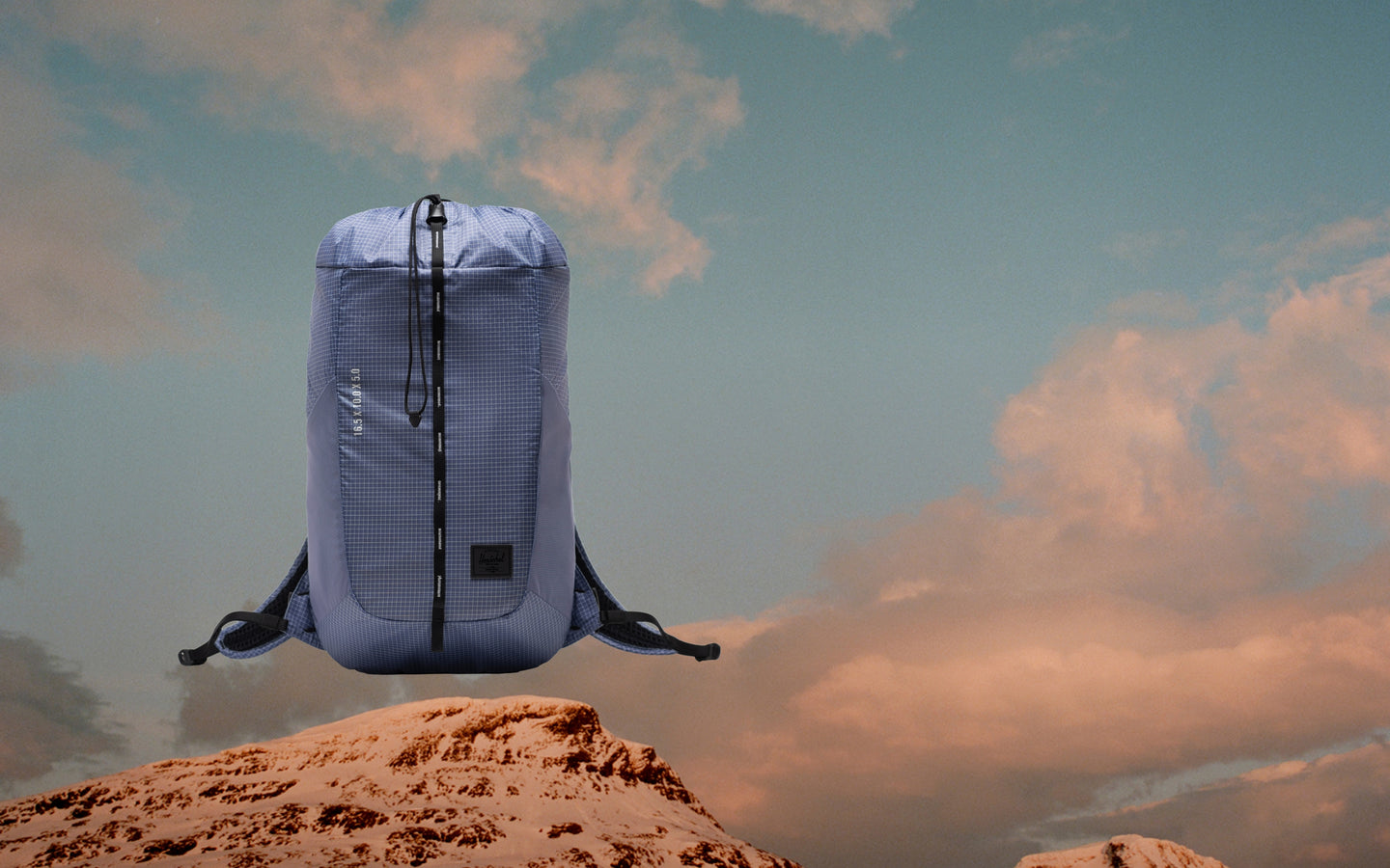 Herschel Supply Co. Ultralight Cinch Daypack 14 L in Heron/Black, shown as a lifestyle or hero shot on a desktop banner background.