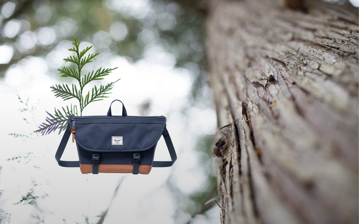 Herschel Supply Co. Cove Small Messenger bag in Navy/Saddle Brown shown from the front against a neutral background.