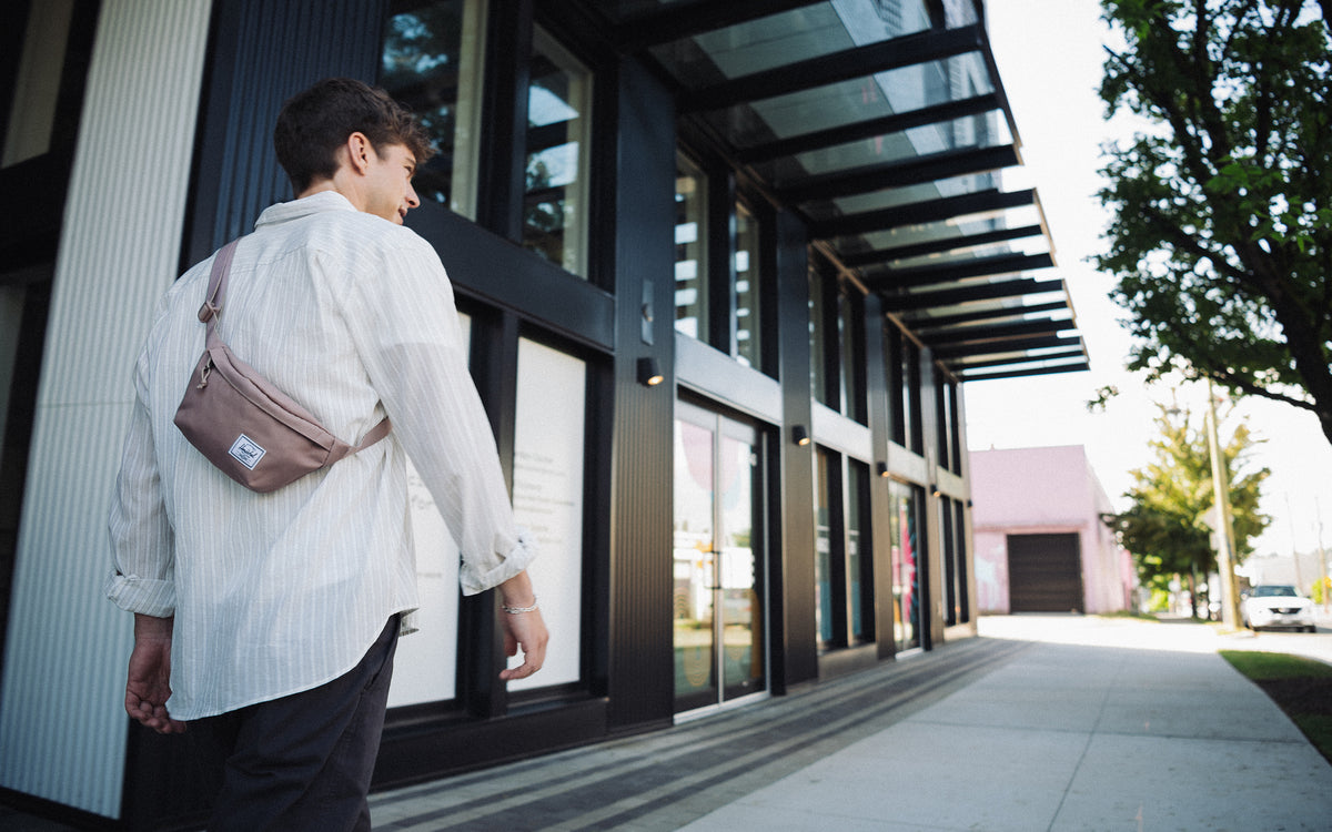 Herschel Classic Hip Pack in Ash Rose, a muted pink belt bag with a zippered main compartment and an adjustable black webbing strap.