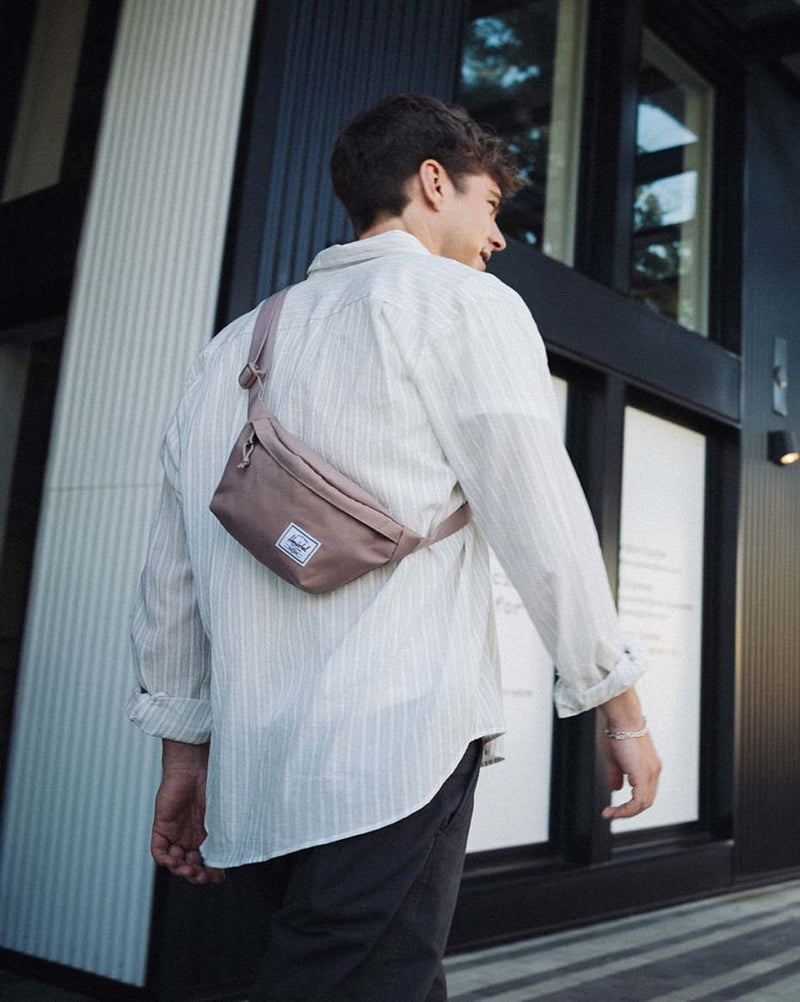 Herschel Classic Hip Pack in Ash Rose, a compact dusty pink waist bag with a zippered main compartment and adjustable strap.