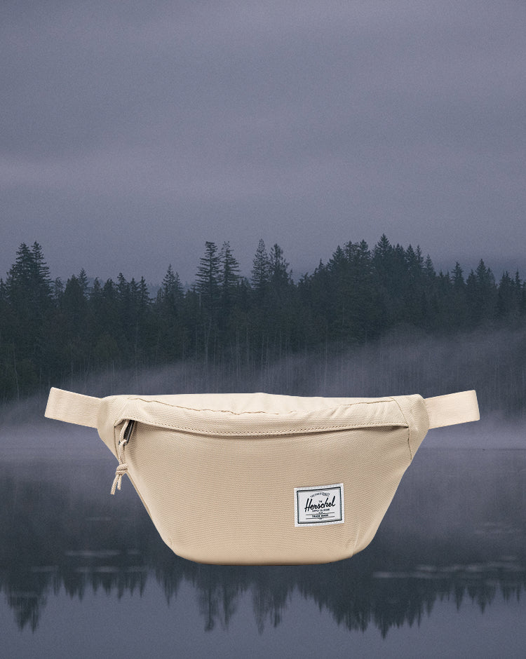 Herschel Supply Co. Herschel Classic Hip Pack in Eucalyptus, a light greenish-gray fanny pack shown on a model.
