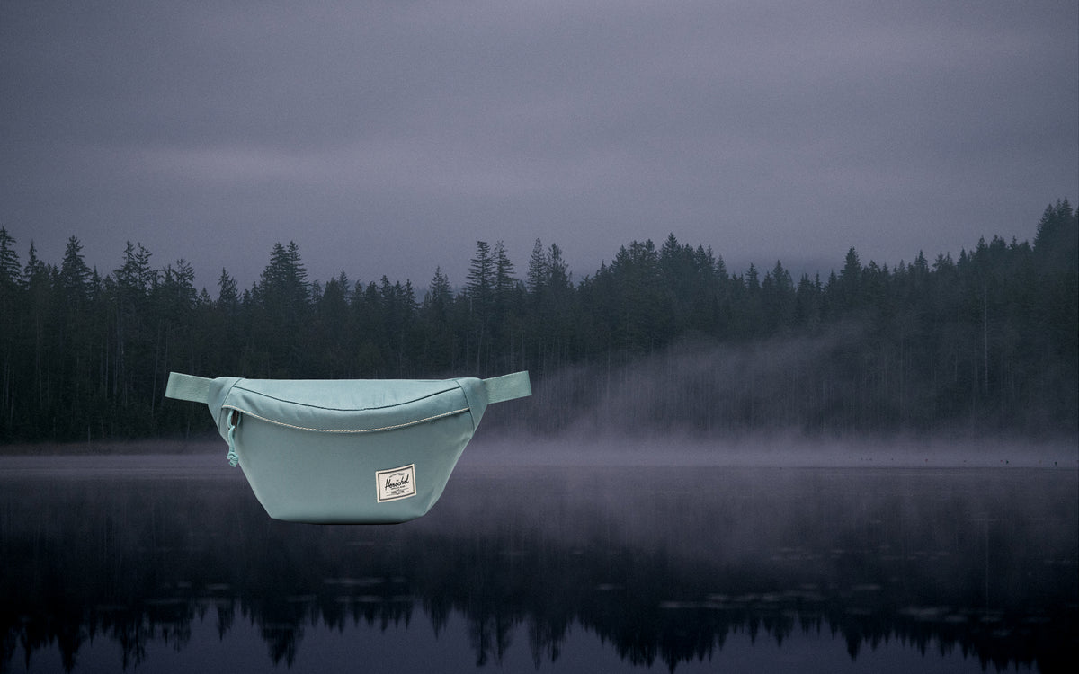 Herschel Classic Hip Pack lifestyle image featuring the bag on a desktop background.