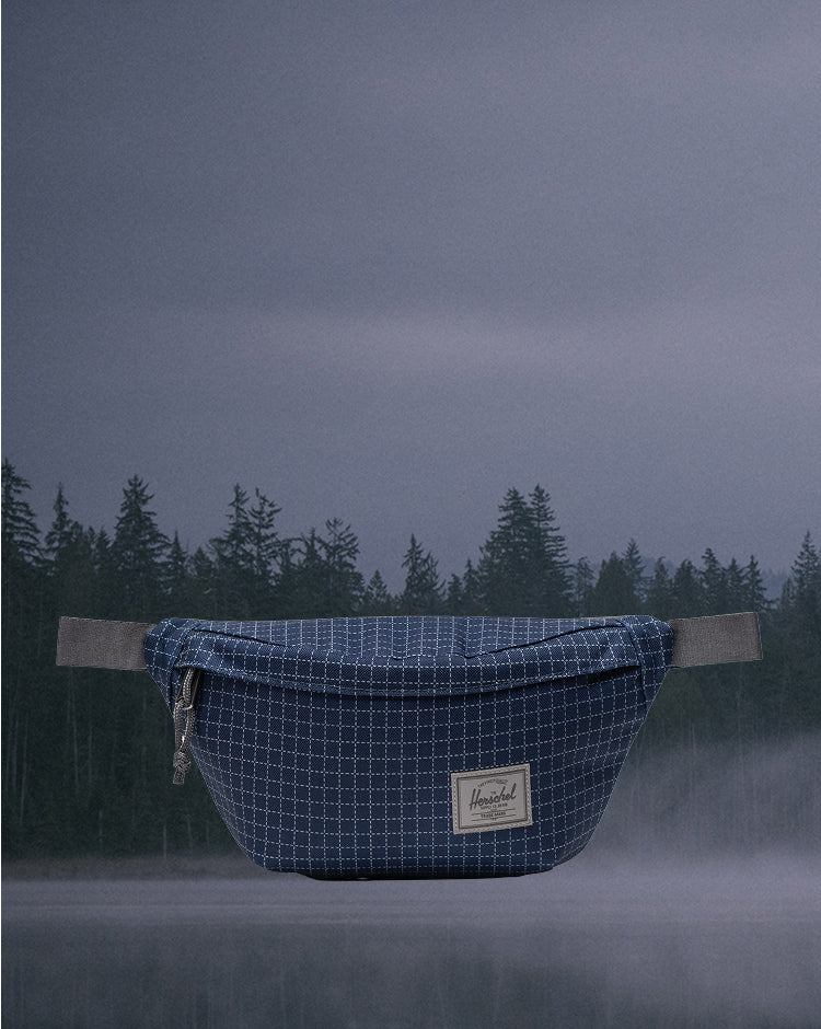 Herschel Classic Hip Pack in Grid Naval Academy and Magnet gray, showing a front view of the compact waist bag.