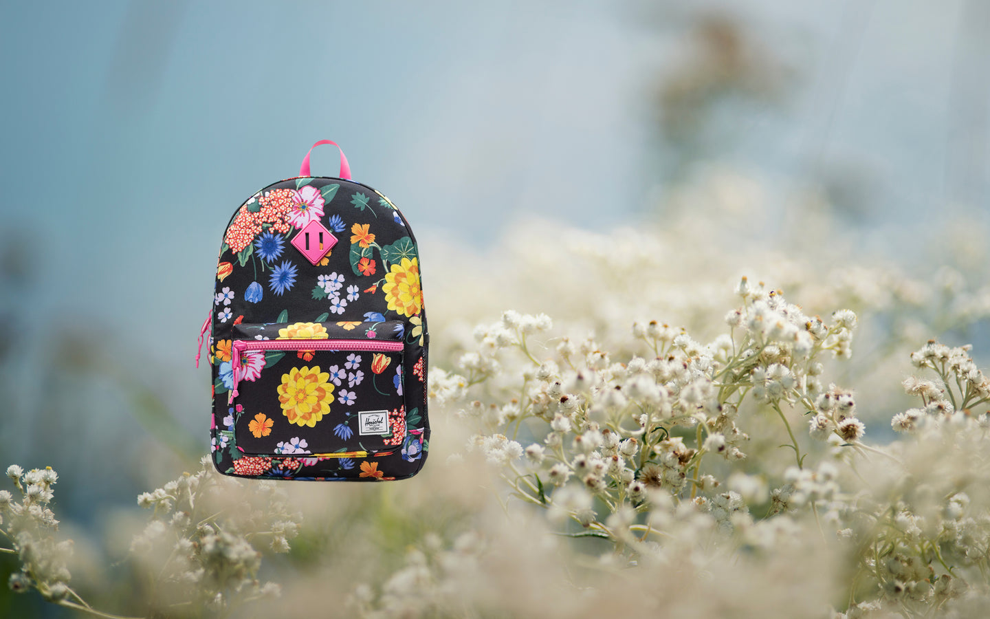 Herschel Heritage Youth Backpack in Paper Garden floral print, shown from the front on a desktop background display.