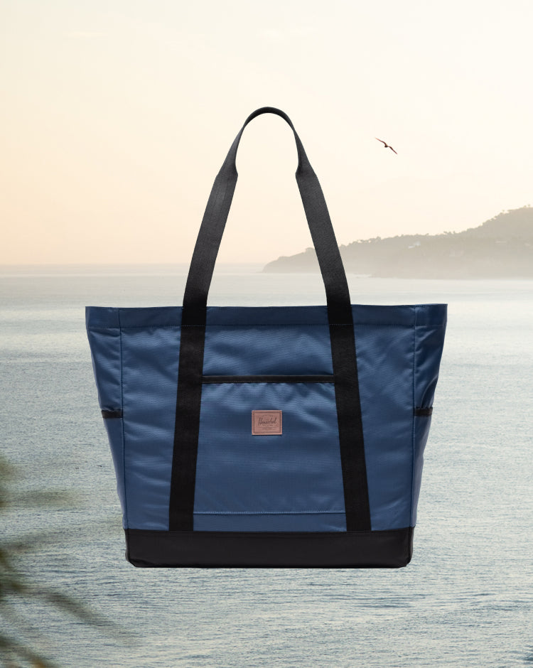 Herschel Heritage Tote in Oceana blue, featuring a classic canvas design with dual top handles and a front zippered pocket.
