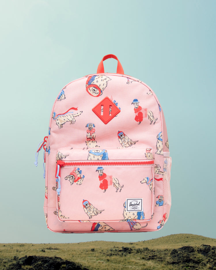 Herschel Heritage Kids Backpack in Fashion Dogs pattern featuring playful cartoon dogs printed all over.