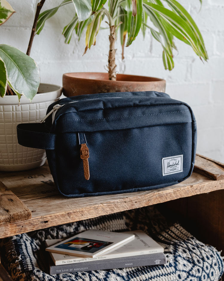 Herschel Supply Co. Chapter Travel Kit in navy blue, featuring a classic compact design with a front zippered pocket and side carrying handle.