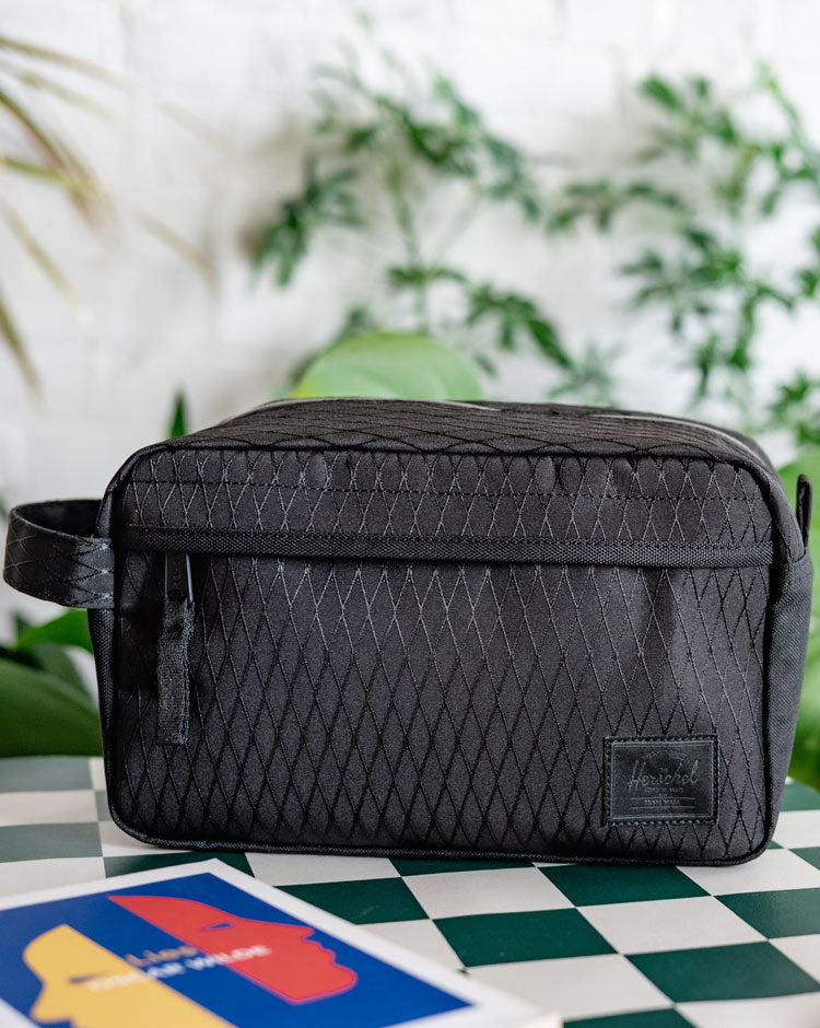 Herschel Supply Co. Chapter Travel Kit in Black Diamond/Black, showcasing its durable design, waterproof zipper, and convenient carrying handle.