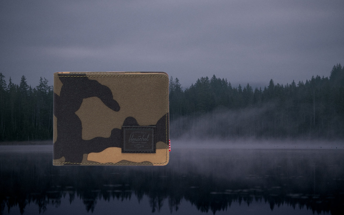 Herschel Supply Co. Roy Wallet in Woodland Camo with a classic bi-fold design and the signature black woven label on the front.