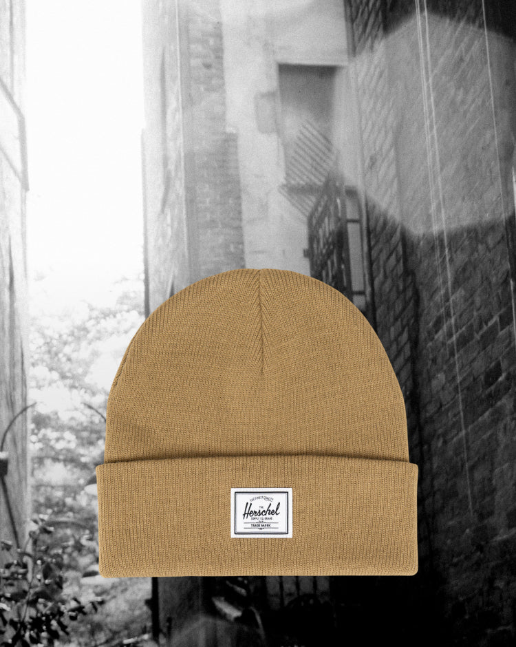 Herschel Supply Co. Elmer Beanie in Antique Bronze. A classic knit beanie featuring a cuffed brim and a woven Herschel logo label on the front.