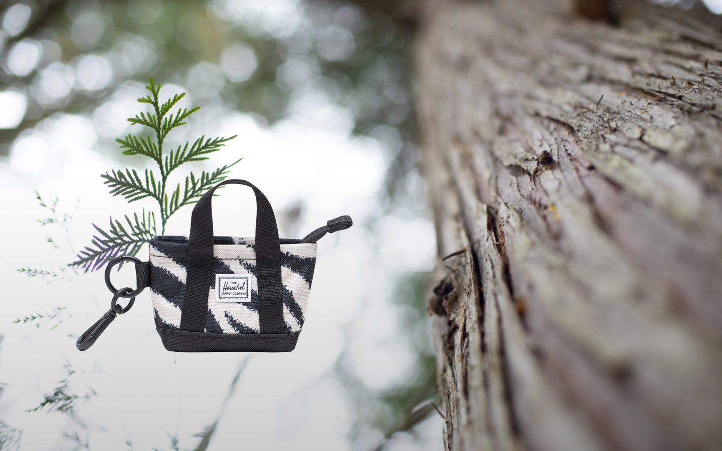 Herschel Supply Co. Herschel Heritage Tote Bag Charm in zebra print, showcasing its compact, stylish design as a miniature accessory.