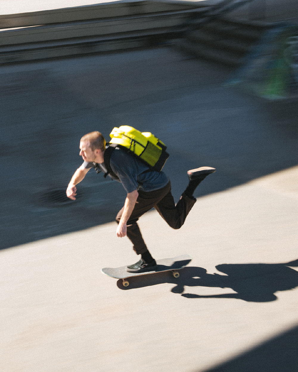 man skateboarding with yellow insulated miller backpack on