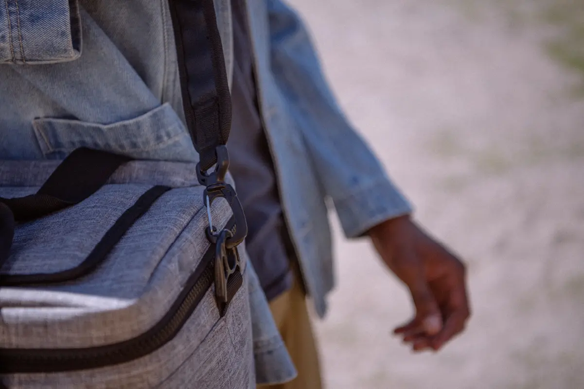 A person walking with a Herschel Pop Quiz Cooler 30 Pack Insulated over their shoulder.