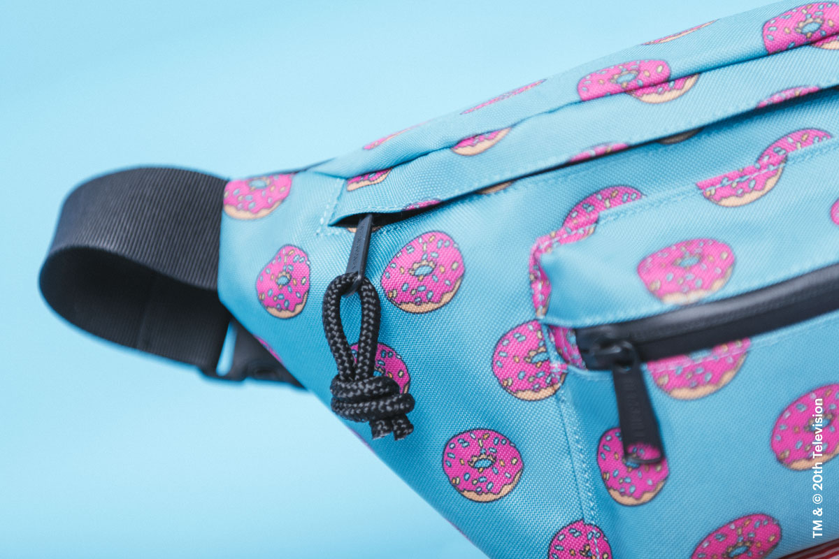 A close-up on the external front pocket and zipper pulls on the Homer Simpson Seventeen Hip Pack from The Simpsons™ x Herschel Supply Company collection
