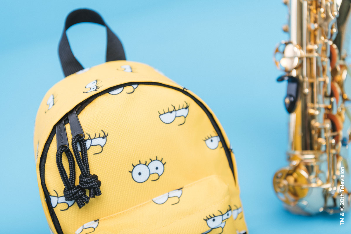 A shot of the Lisa Simpson Classic Backpack Mini Simpsons showing it's zipper pulls with a saxophone in the background behind it
