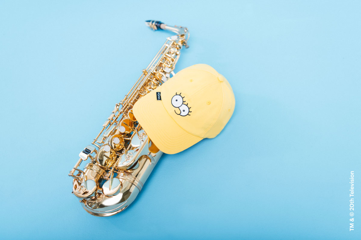 The Sylas Cap Simpsons in Lisa Simpson print on top of a saxophone.
