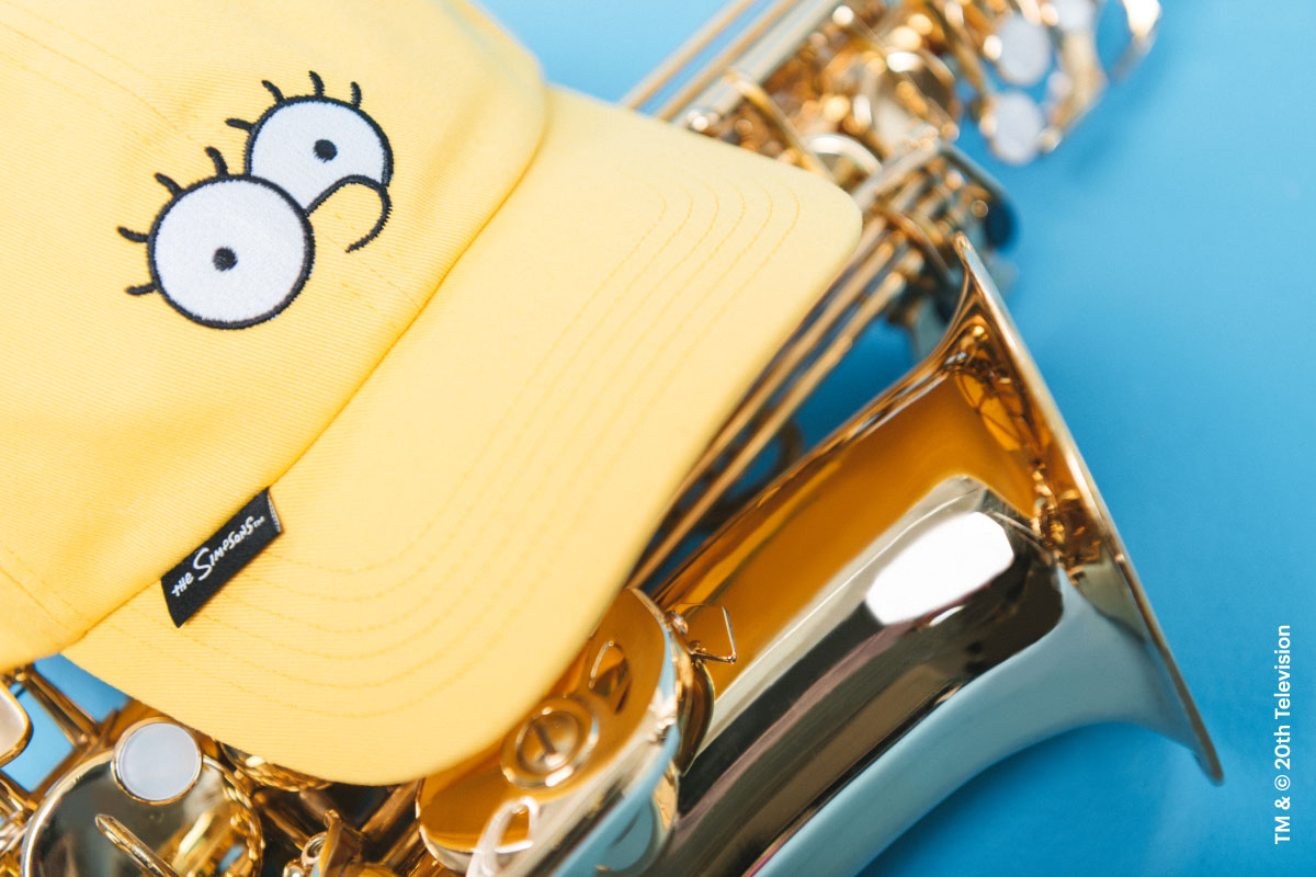 A close-up shot of the Sylas Cap Simpsons in Lisa Simpson print on top of a saxophone showing the custom flag label